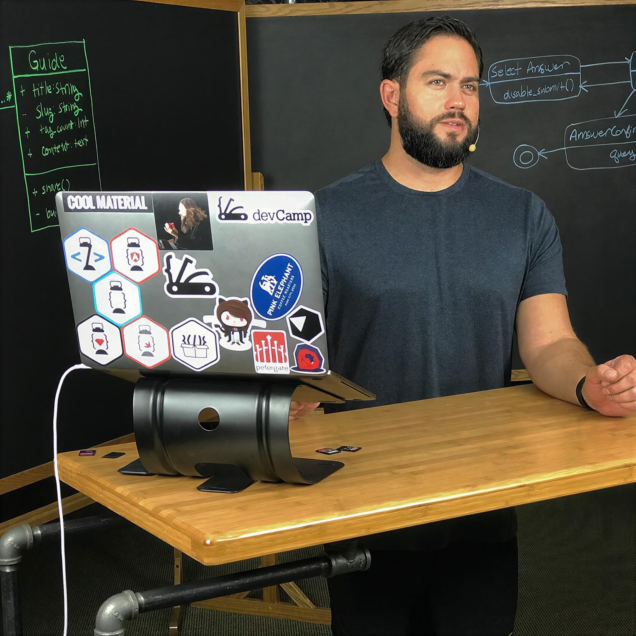 Jordan recording a programming lesson at a laptop in front of a chalkboard of software diagrams